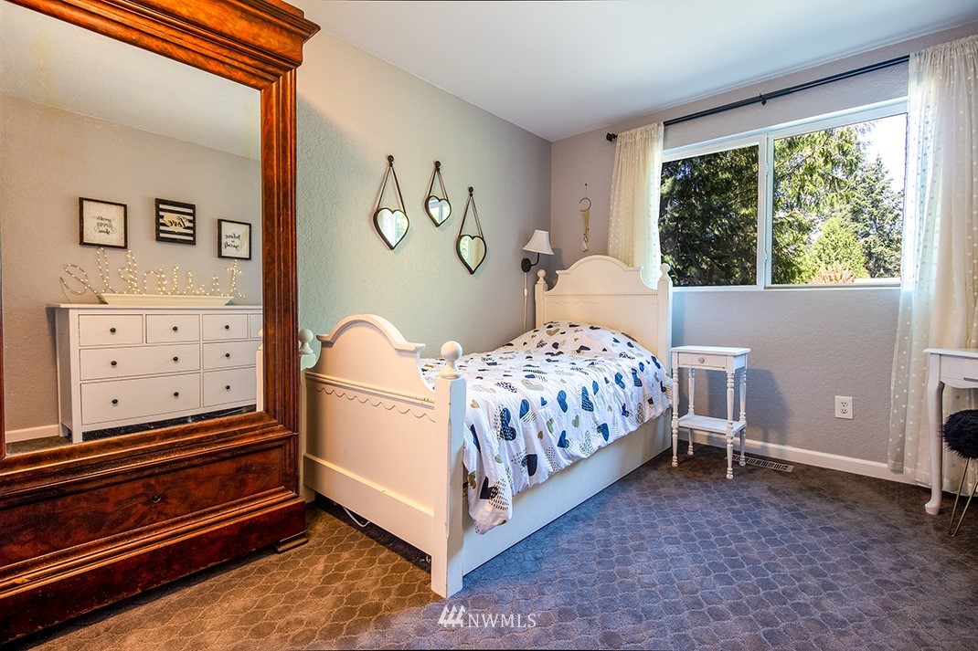 10025 Northeast 204th Street Bothell, WA 98011 - Photo 23 of 40 a bedroom with a bed and a window
