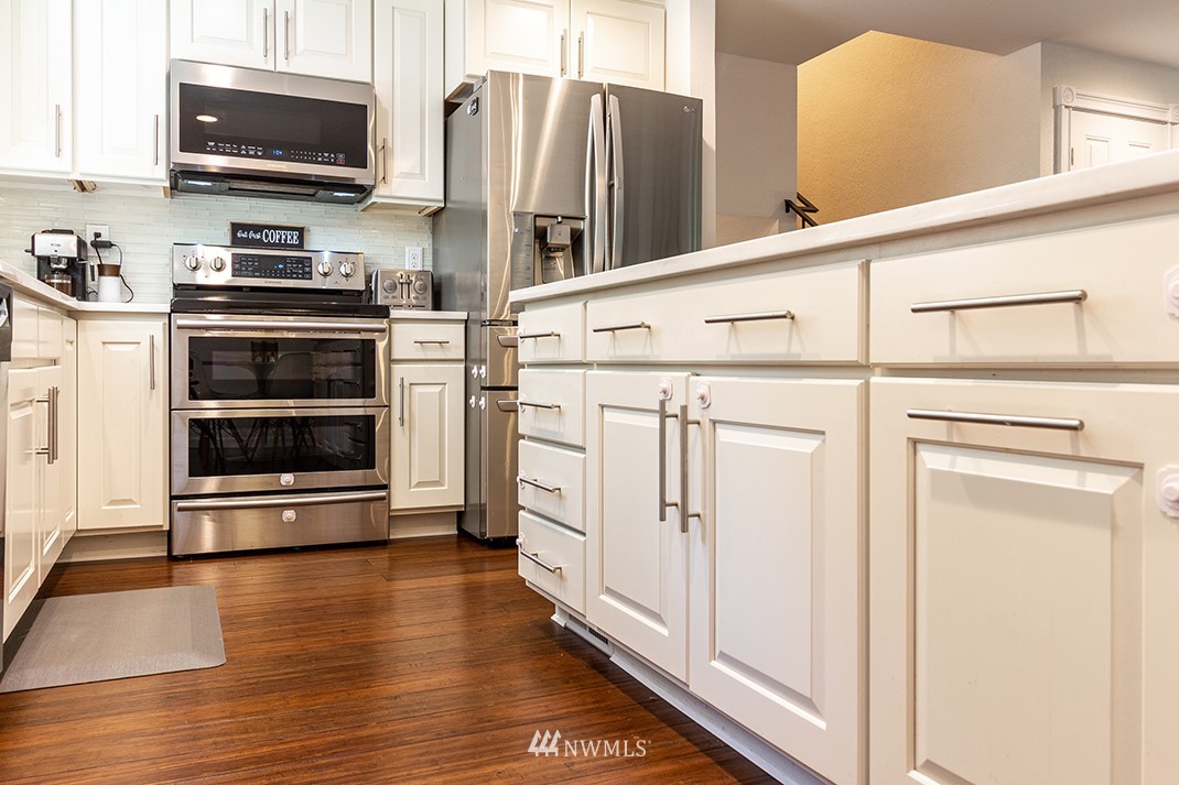 10025 Northeast 204th Street Bothell, WA 98011 - Photo 8 of 40 a kitchen with stainless steel appliances a stove microwave and a refrigerator