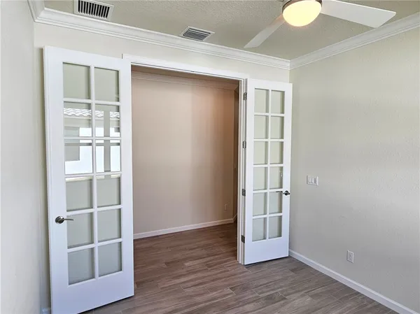 a view of empty room with wooden floor and entryway