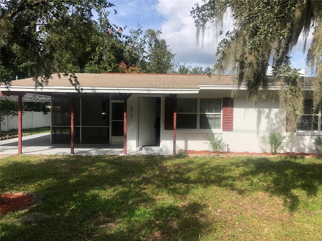 8905 Old Silver Star Road Orlando, FL 32818 - Photo 1 of 1 a view of a white house with a big yard and large trees