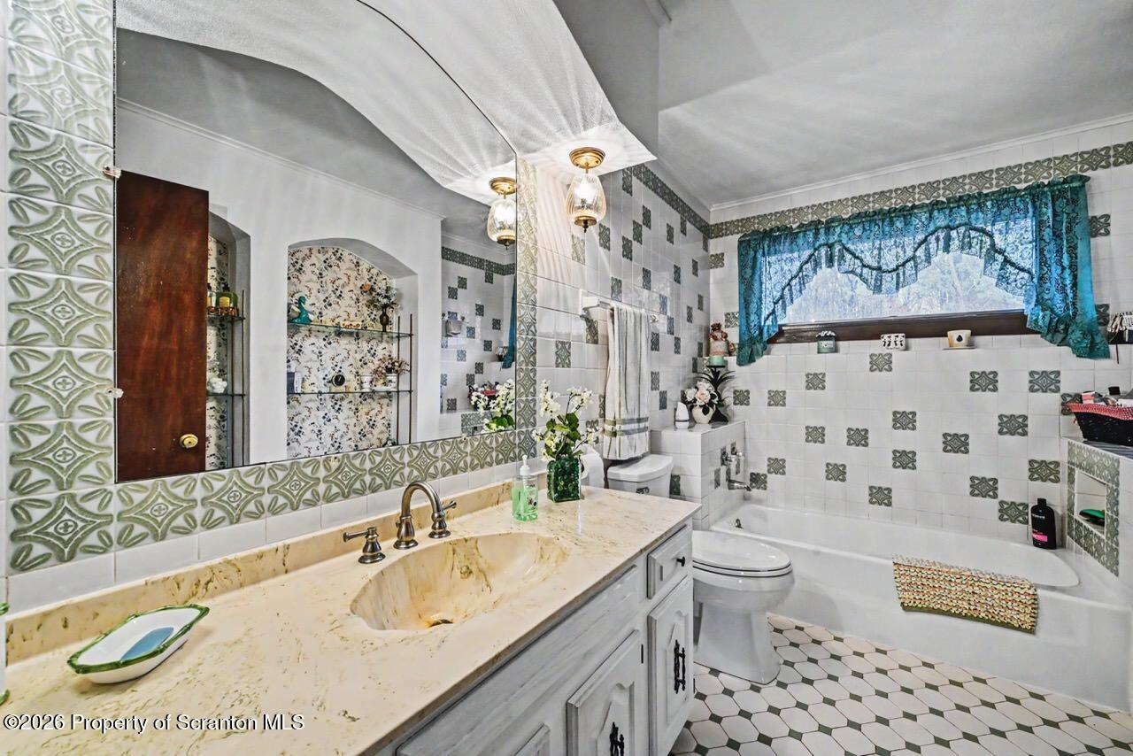 73 Quinton Road Scott Township, PA 18447 - Photo 45 of 64 a bathroom with a sink a toilet a mirror a vanity and shower