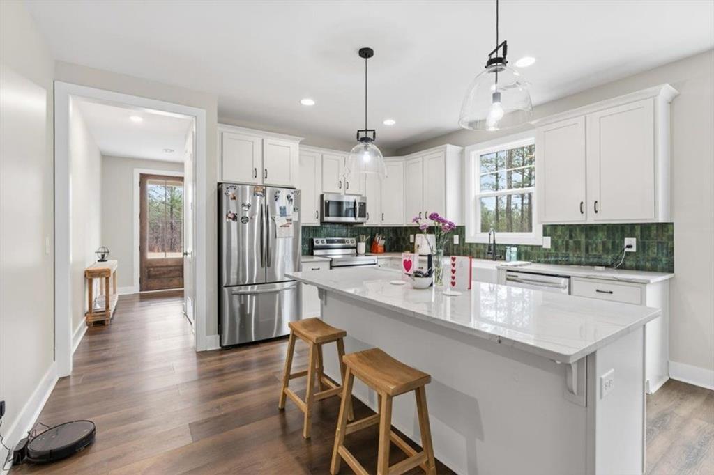 1270 McGarity Road Temple, GA 30179 - Photo 16 of 58 a kitchen with stainless steel appliances granite countertop a refrigerator a sink dishwasher a stove and white cabinets with wooden floor