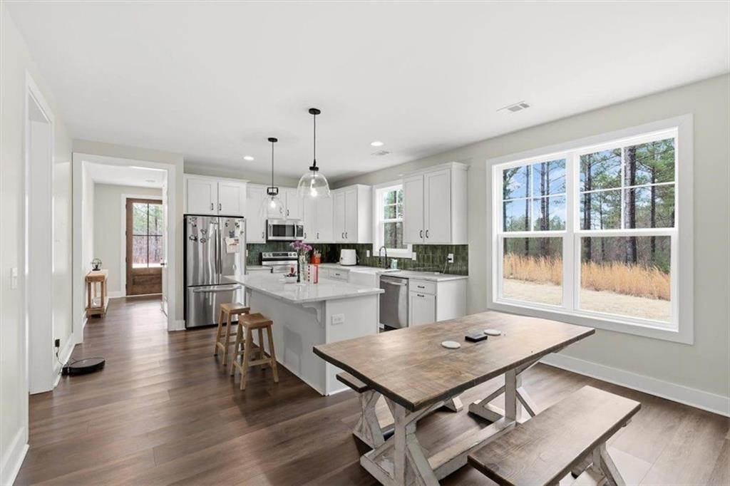 1270 McGarity Road Temple, GA 30179 - Photo 22 of 58 a kitchen with a table chairs refrigerator and cabinets