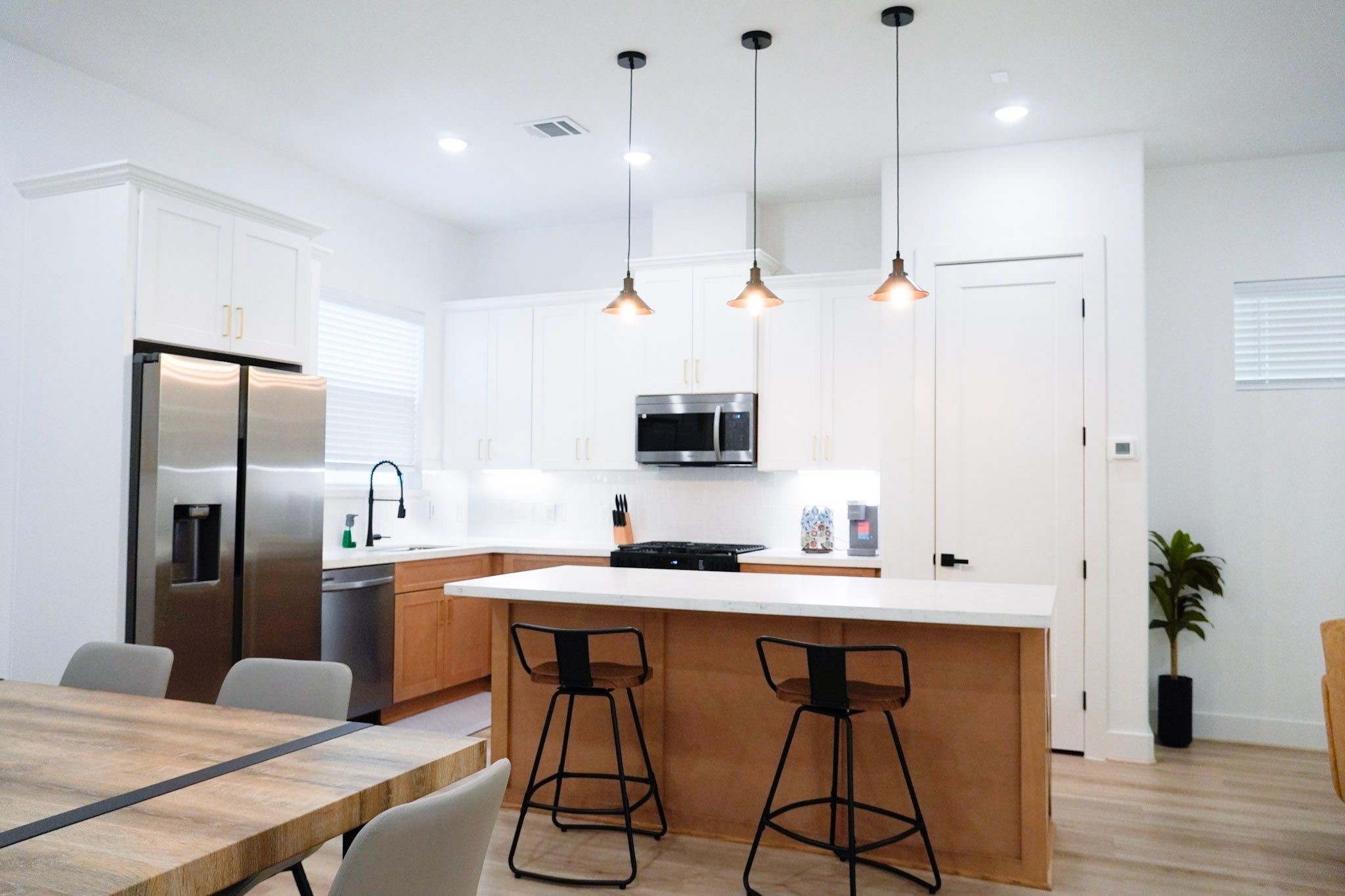 2706 Cochran Street Houston, TX 77009 - Photo 16 of 23 a kitchen with stainless steel appliances kitchen island granite countertop a table chairs in it and wooden floors