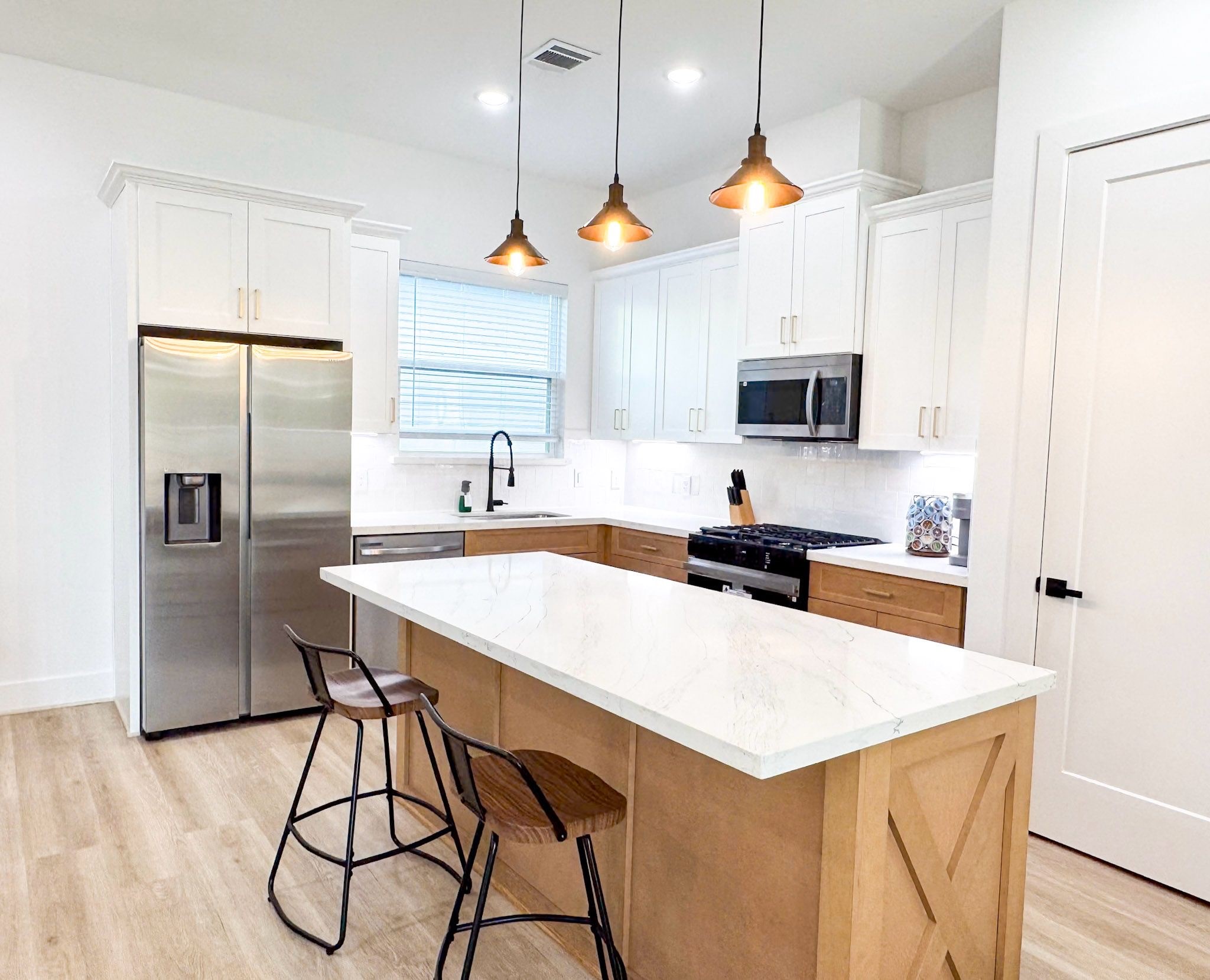 2706 Cochran Street Houston, TX 77009 - Photo 9 of 23 a kitchen with stainless steel appliances granite countertop a sink a stove a refrigerator and a dining table with wooden floor