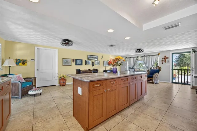 a open kitchen with stainless steel appliances granite countertop a sink counter and chairs