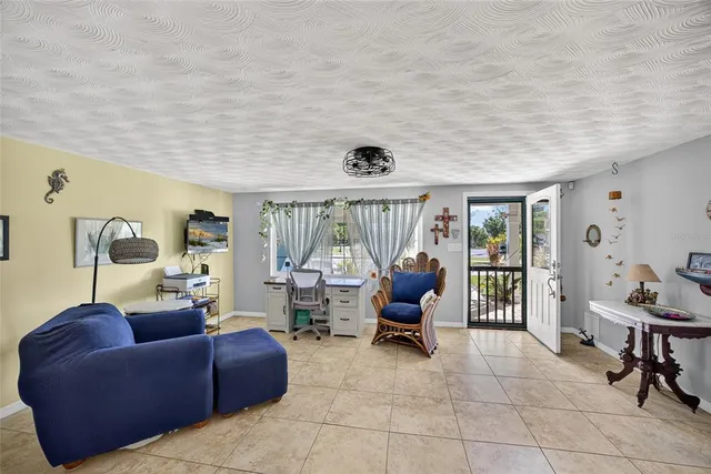 a living room with furniture and a floor to ceiling window