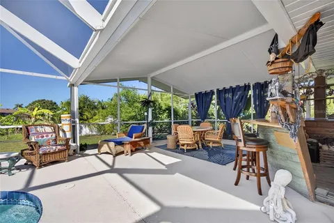 a living room with patio furniture and a floor to ceiling window