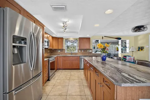 a kitchen with stainless steel appliances granite countertop a refrigerator and a sink