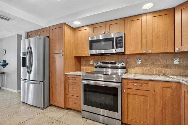 a kitchen with stainless steel appliances granite countertop a refrigerator stove and microwave