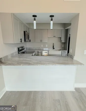 a kitchen with stainless steel appliances granite countertop a sink a stove and a refrigerator