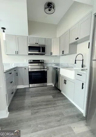 a kitchen with stainless steel appliances granite countertop a stove sink and cabinets