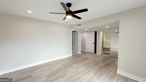 an empty room with wooden floor and windows