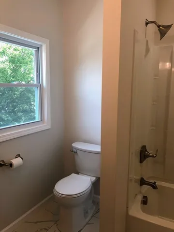 a bathroom with a toilet and a shower