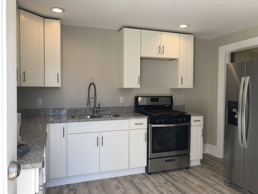 28-32 Calvary Street Waltham, MA 02453 - Photo 18 of 41 a kitchen with a sink stove and cabinets