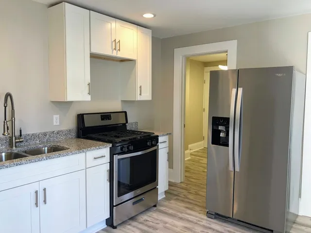 a kitchen with stainless steel appliances granite countertop a stove a refrigerator and a sink