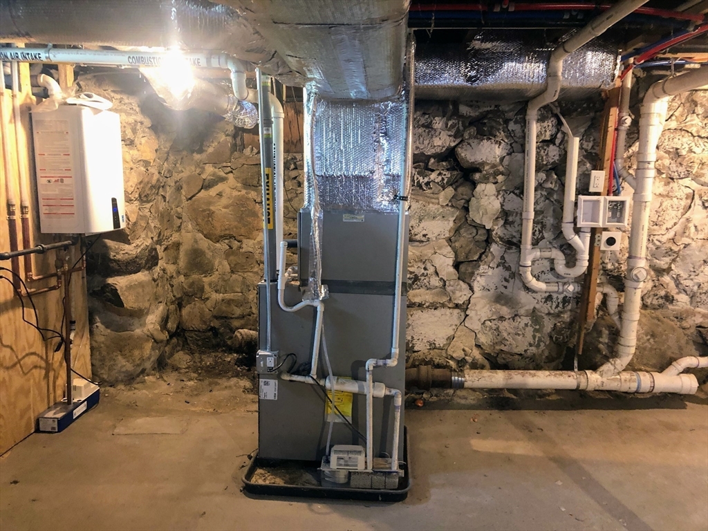 28-32 Calvary Street Waltham, MA 02453 - Photo 29 of 41 a room with water heater and a wooden door