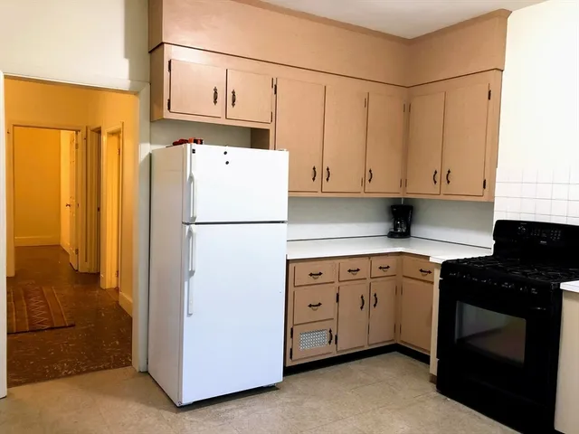 a kitchen with granite countertop white cabinets and a stove
