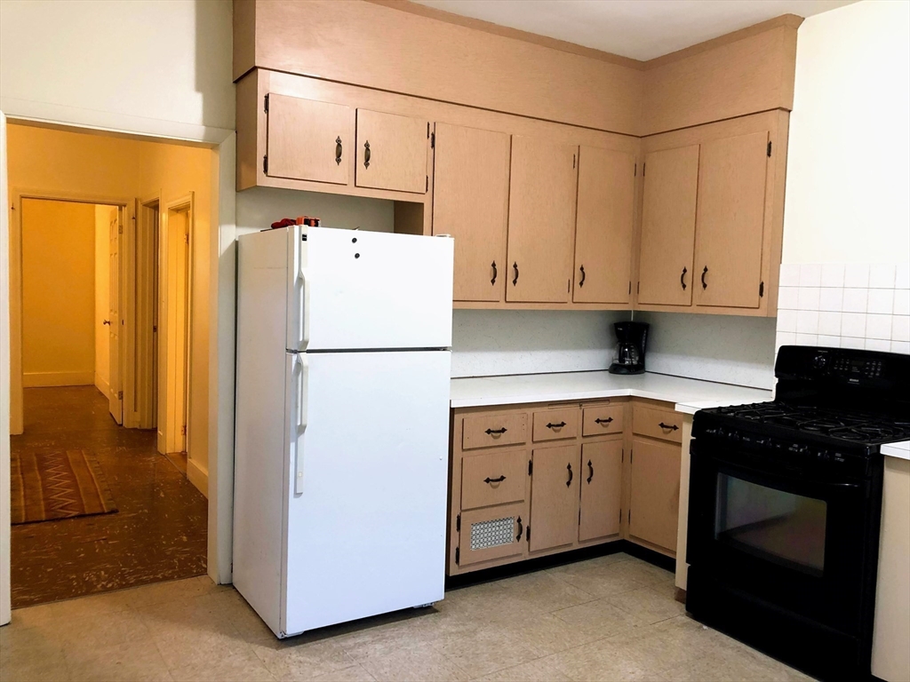 28-32 Calvary Street Waltham, MA 02453 - Photo 31 of 41 a kitchen with refrigerator a stove a sink and cabinets