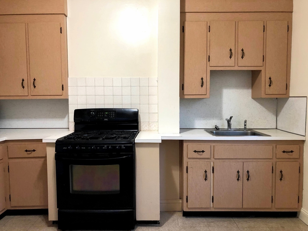 28-32 Calvary Street Waltham, MA 02453 - Photo 32 of 41 a kitchen with granite countertop white cabinets and a stove