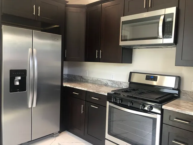 a kitchen with granite countertop stainless steel appliances and wooden cabinets