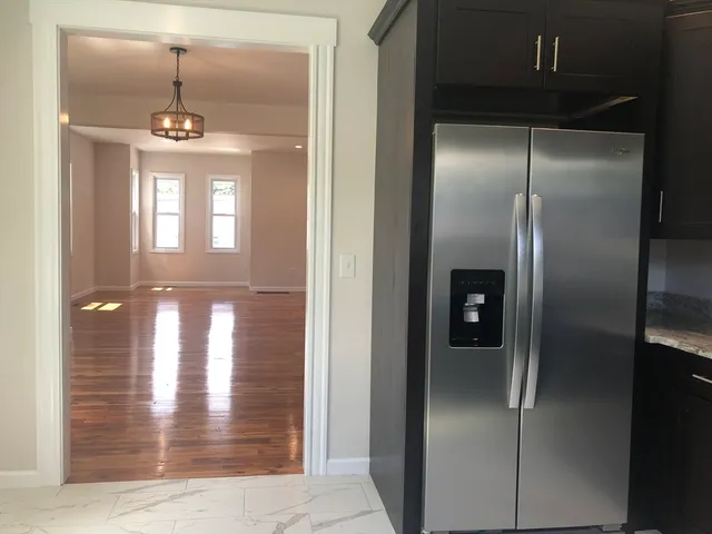a view of a refrigerator in kitchen and a sink