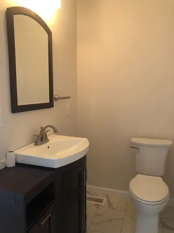 a bathroom with a toilet a sink and mirror