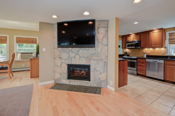 122 Barton Road Stow, MA 01775 - Photo 13 of 30 a living room with stainless steel appliances furniture a fireplace and a flat screen tv