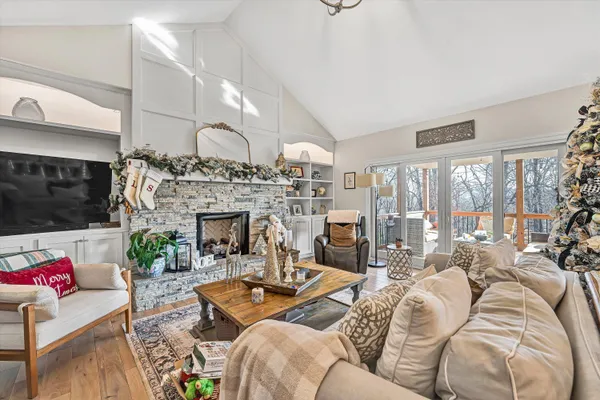 a living room with furniture a fireplace and a floor to ceiling window