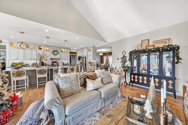 a living room with furniture kitchen view and a large window
