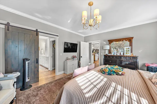 a bedroom with a bed and a flat tv screen on dresser