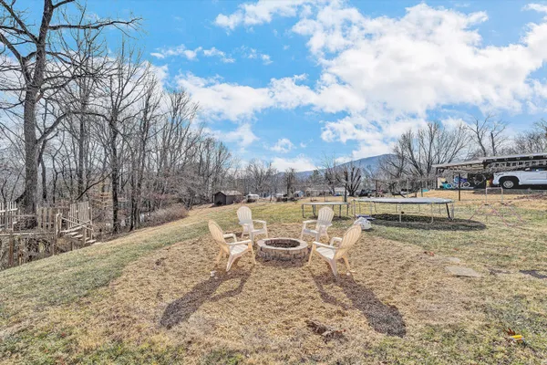 a view of a backyard with table and chairs and a fire pit