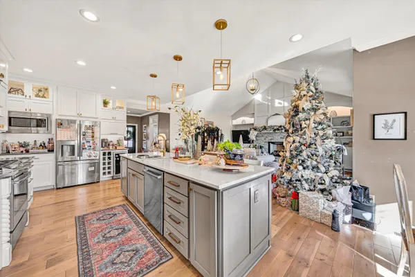 a kitchen with stainless steel appliances kitchen island granite countertop a stove a sink and a refrigerator