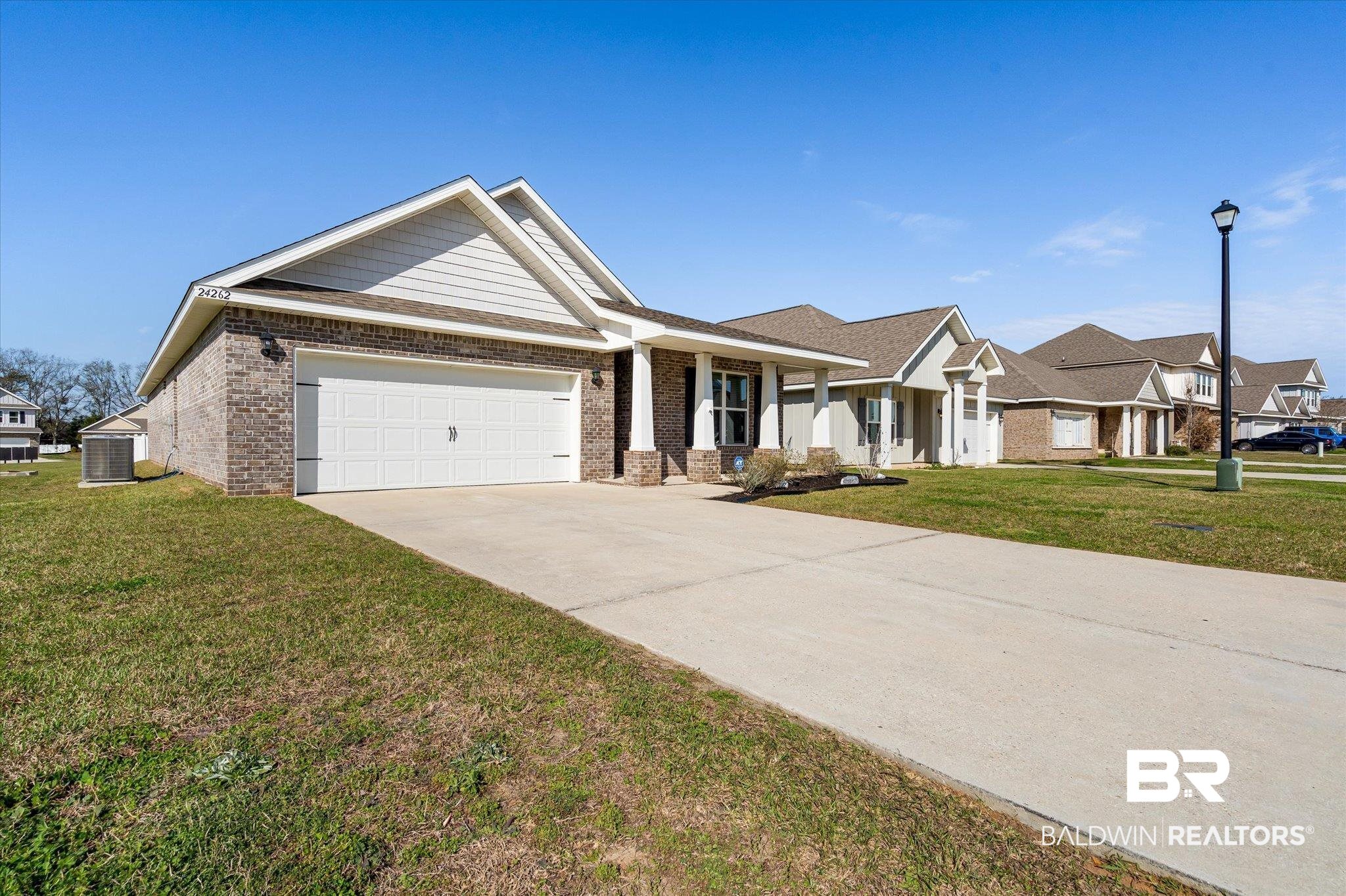 24262 Alydar Loop Daphne, AL 36526 - Photo 17 of 33 View of front facade featuring a front lawn, cooling unit, brick siding, and an attached garage