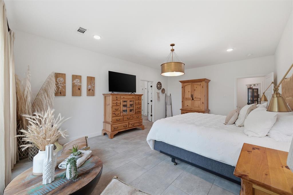 434 Sandstone Court Sunset, TX 76270 - Photo 17 of 40 a spacious bedroom with a bed and a flat screen tv