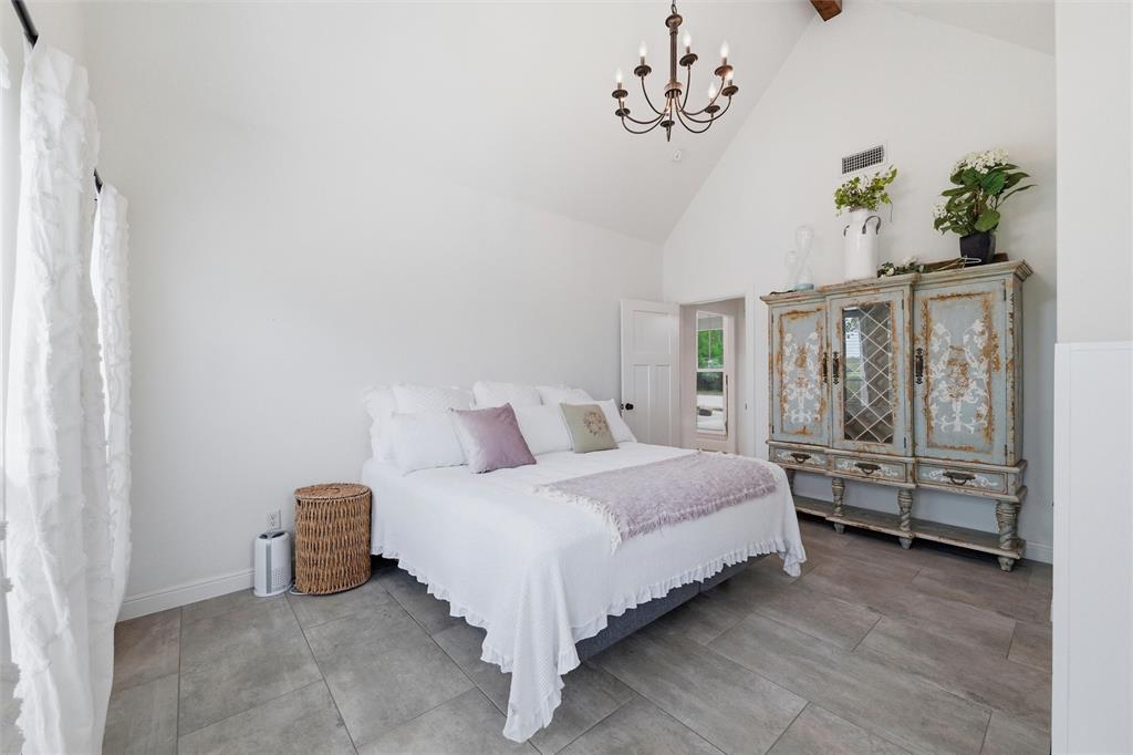 434 Sandstone Court Sunset, TX 76270 - Photo 26 of 40 a bedroom with a bed and a chandelier
