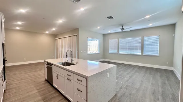 a kitchen that has a sink a stove and wooden floor