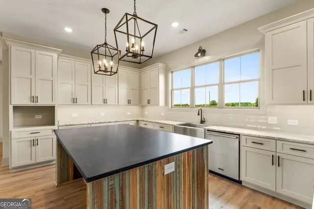 a kitchen with cabinets a center island and stainless steel appliances