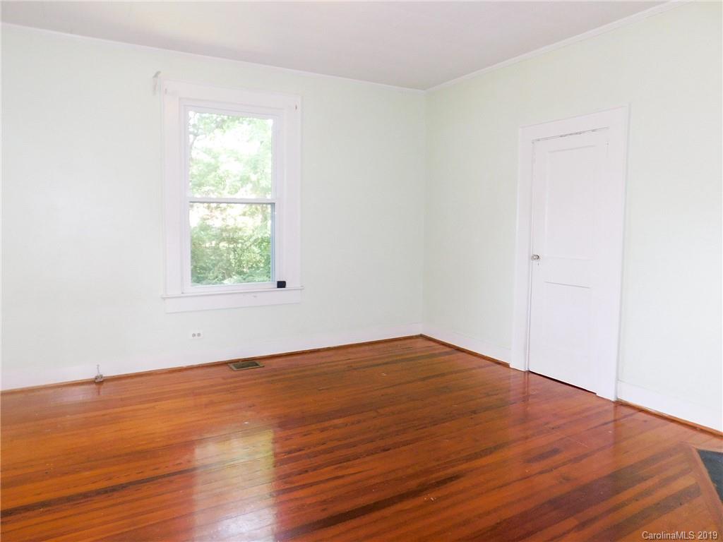 6201 Rumple Road Charlotte, NC 28262 - Photo 6 of 22 an empty room with wooden floor and windows