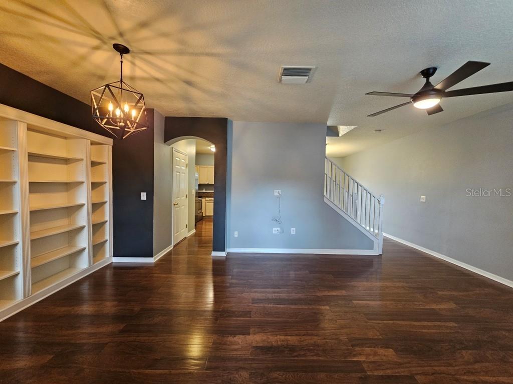 1404 Blue Magnolia Road Brandon, FL 33510 - Photo 2 of 21 a view of a hallway with wooden floor and a chandelier