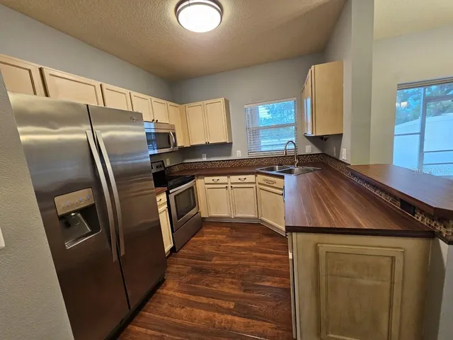 a kitchen with granite countertop a refrigerator sink and stove