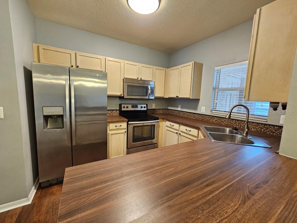 1404 Blue Magnolia Road Brandon, FL 33510 - Photo 8 of 21 a kitchen with granite countertop a refrigerator and a stove top oven