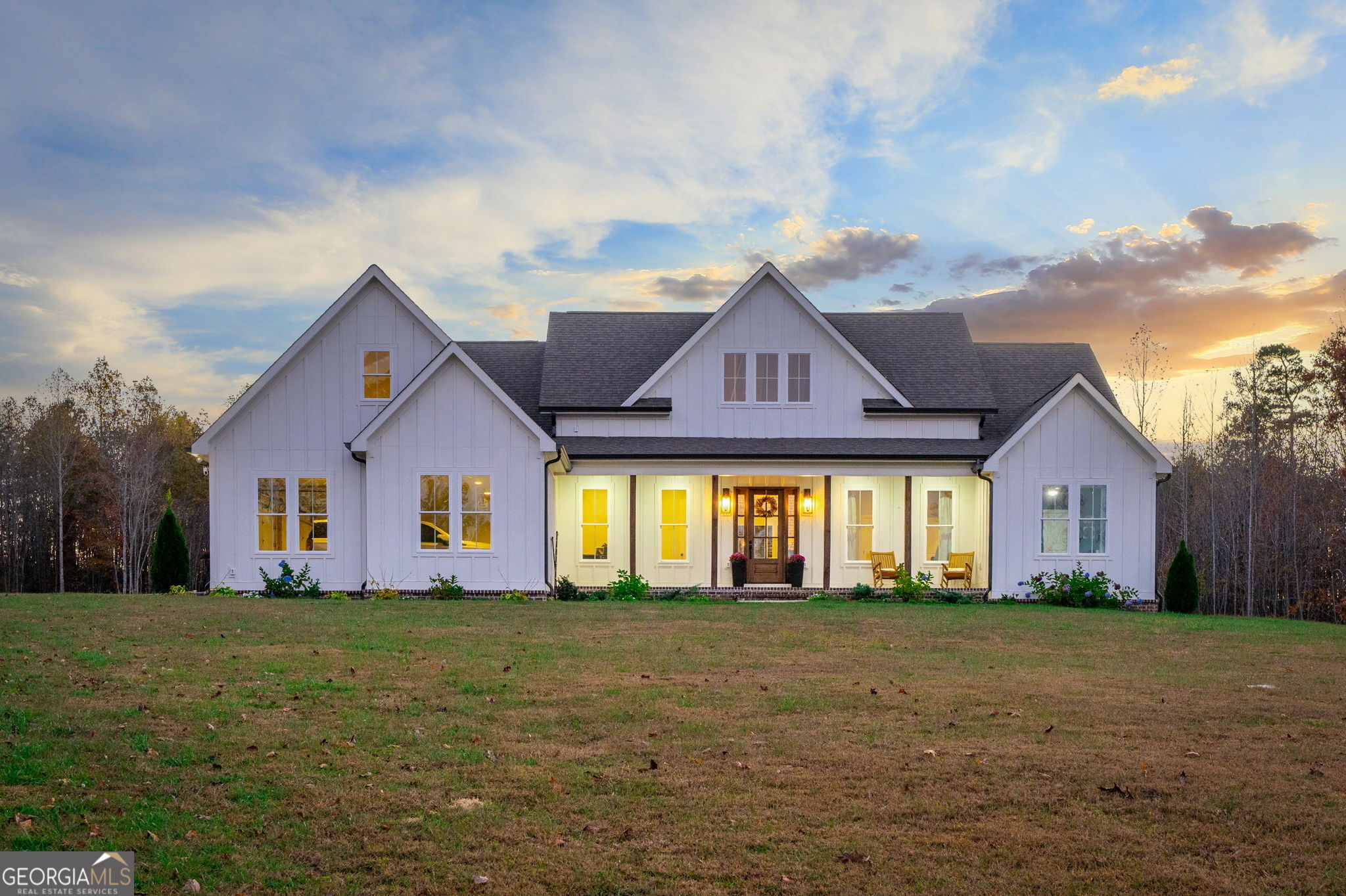 a front view of house with yard and trees in the background