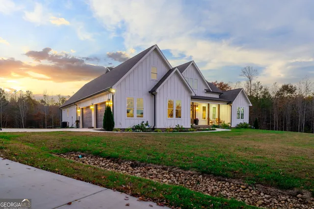 a front view of a house with a yard and trees