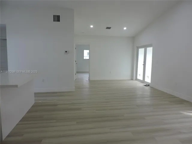 a view of an empty room and wooden floor