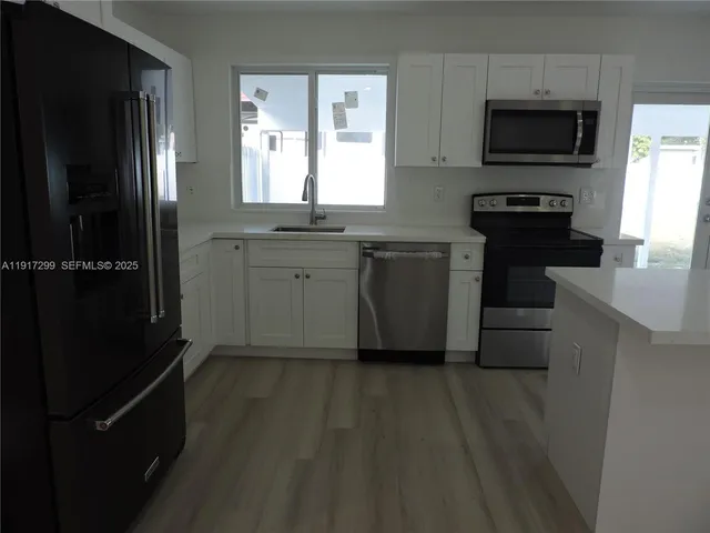 a view of empty room with window and wooden floor