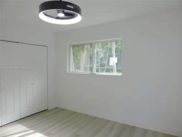 a kitchen with cabinets and wooden floor