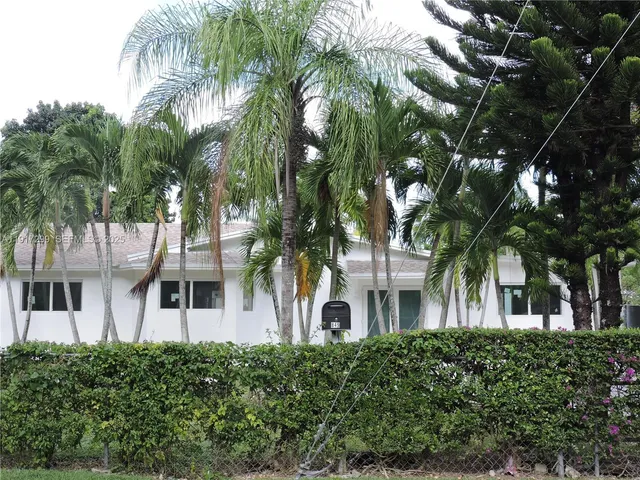 a big white house with a big yard and large trees