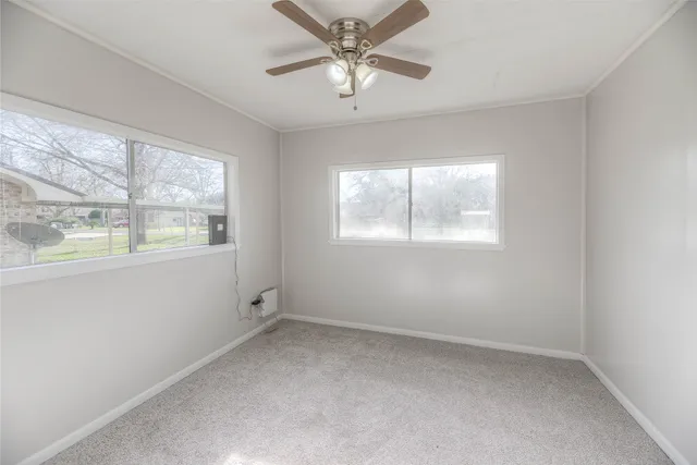 an empty room with a window and a ceiling fan