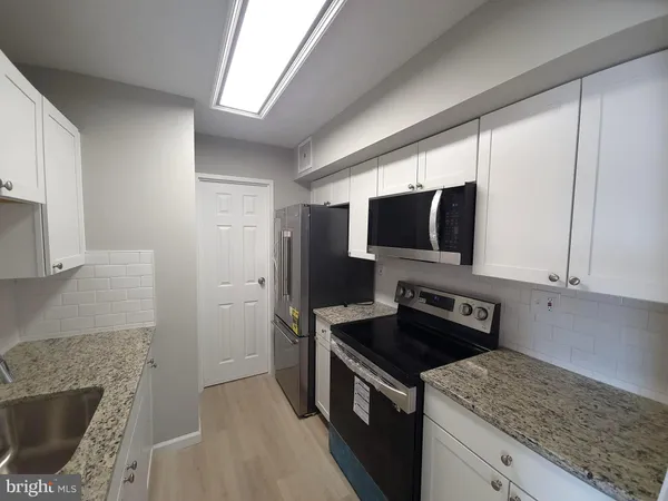a kitchen with a stove microwave and sink